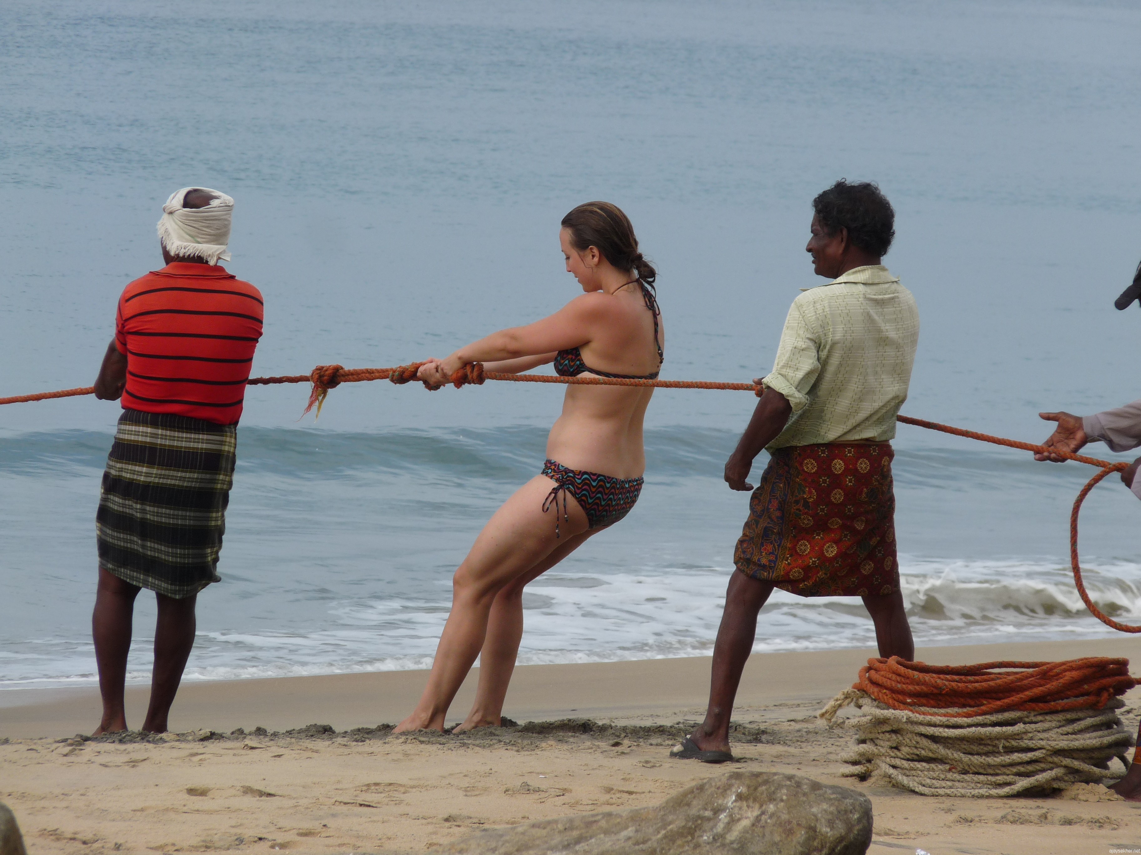 Lady Christ among the fisher folk: A white woman helping the fishermen to pull the loop-net from the sea at Black Beach, Varkala.