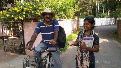 Prof P J Cherian on a cycle that is part of the green archeology of Pattanam project and Ms Mikky the research assistant with a Pattanam ware at Pattanam, 19 Apl 2014.
